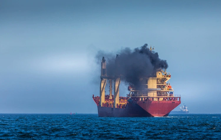 Cargo ship emitting large amount of black smoke