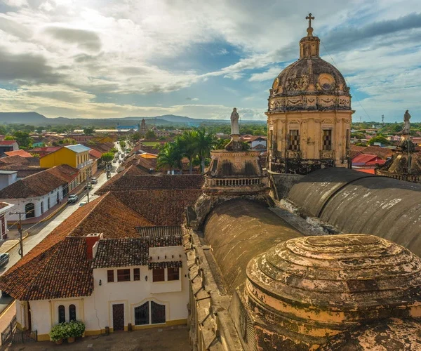 Urban cityscape of the city of Granada at sunset with the Merced church in the foreground in Spanish colonial style architecture, Nicaragua, Central