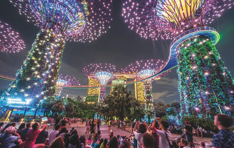 Illuminated Supertrees at Gardens by the Bay at night, with crowds below