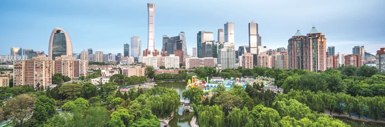 Tuanjiehu Park's trees and lake in front of the Beijing skyline