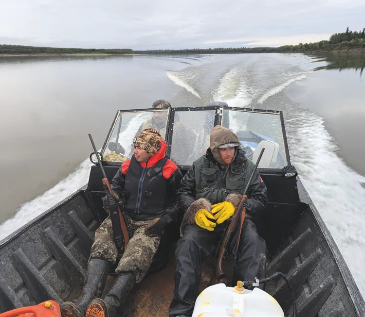 Locals in a boat on a hunting trip on the Koyukuk River