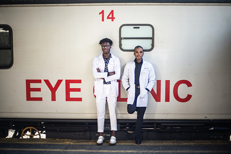 Optometry students Anele Shabalala (left) and Ntsindiso Bidla lean against the Phelophepa’s eye clinic carriage