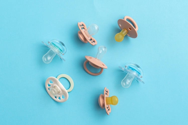 Baby,Pacifiers,On,Blue,Background,With,Copy,Space,,Top,View