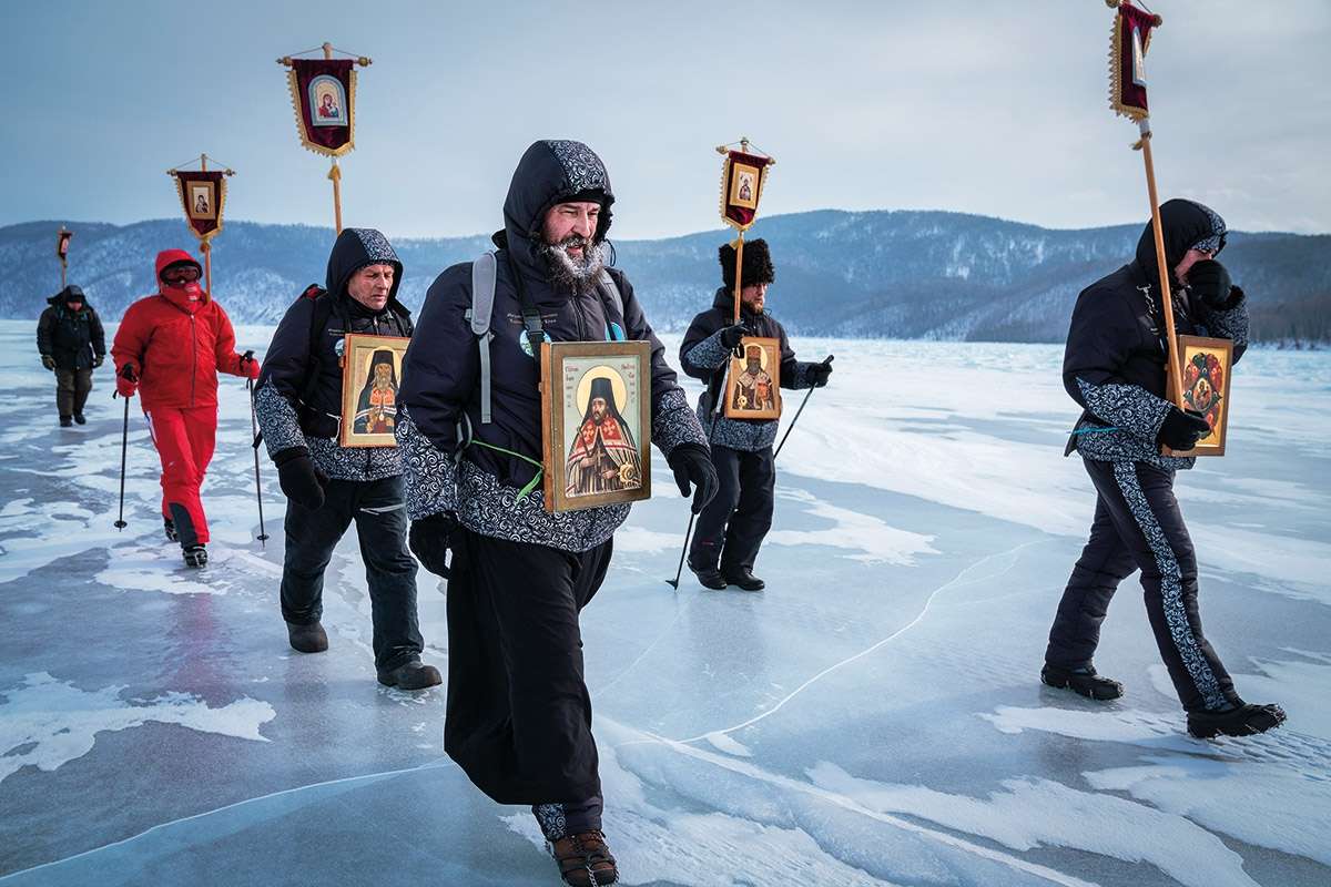 Men carrying religious icons walk over the frozen Lake Baikal