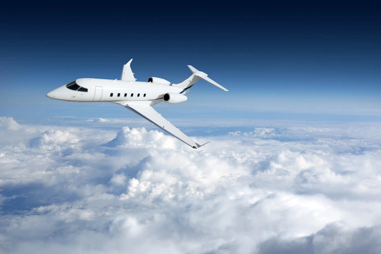 Business jet airplane flying on a high altitude above the clouds