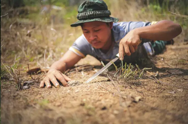 Removing landmines with
makeshift tools and no
protective equipment