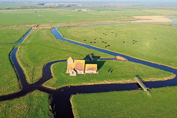 Aerial view of isolated St Thomas à Becket Church in Fairfield, Romney Marsh