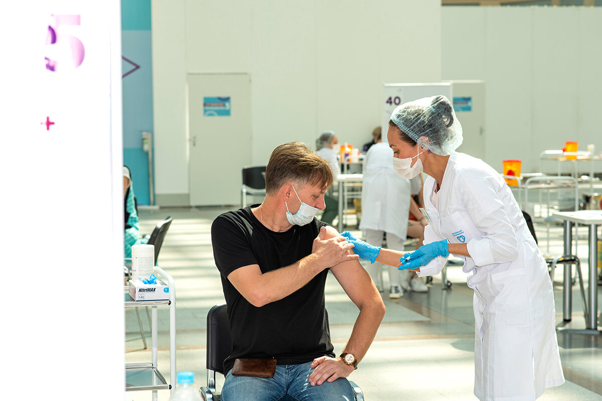 A female doctor administers the coronavirus vaccine to a man in Russia