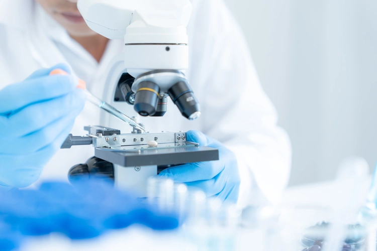 Scientist looking through a microscope.