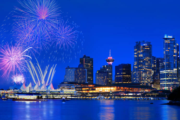 Downtown Vancouver waterfront with fireworks in sky for Canada Day, 2019.