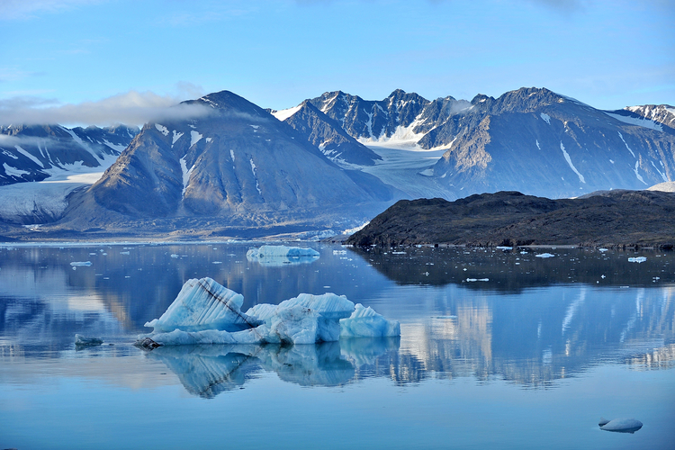 Snowy mountains and drifting icebergs in the Greenland Sea.