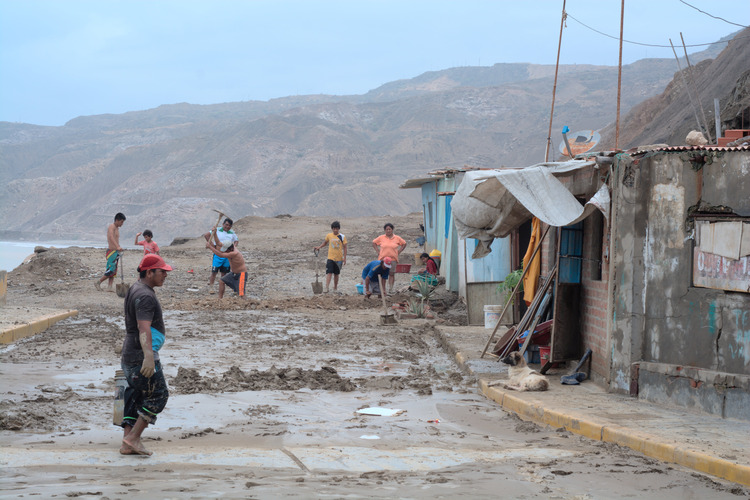  Fishing village residents work to clean their town of mud after flooding brought on my El Niño rains