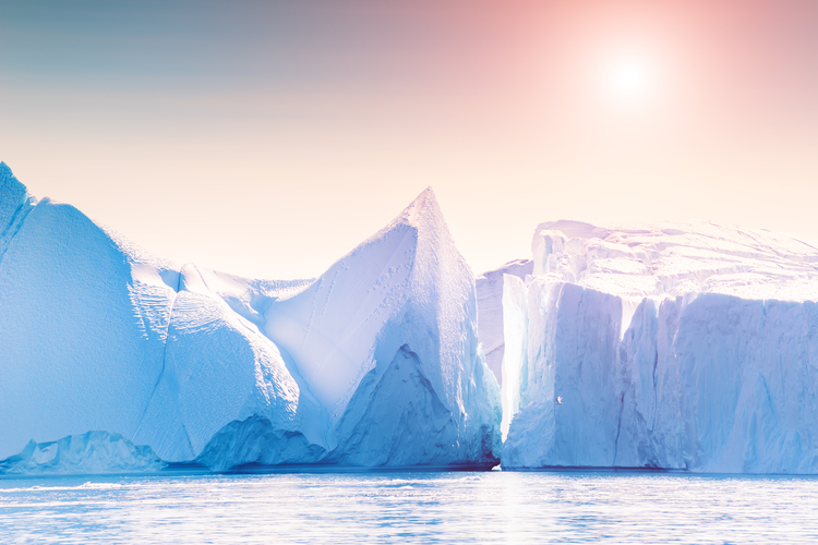 Big blue icebergs in Atlantic ocean at sunrise. Ilulissat icefjord, western Greenland.