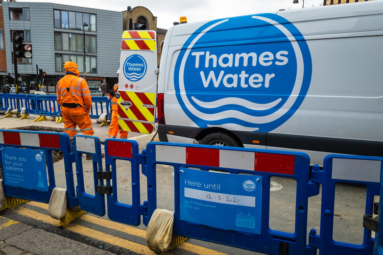 Workers of the British water utility company Thames Water working to upgrade the capital's water supply and waste water infrastructure, stood outside a Thames Water vehicle.