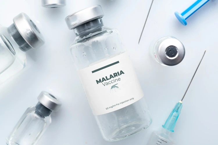 Vaccine bottles and needles labelled 'Malaria'.