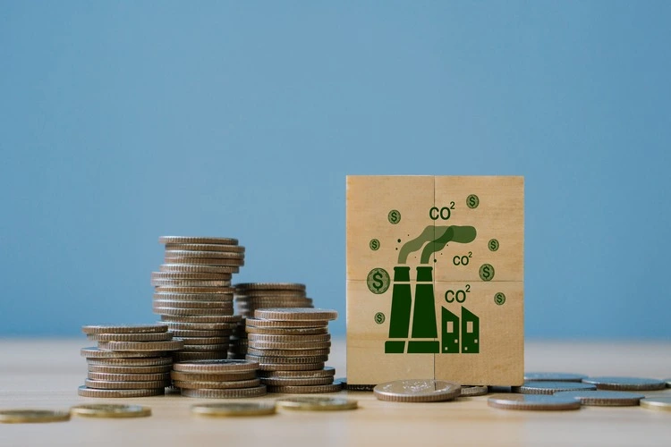 Carbon dioxide graphics beside a stack of coins, indicating carbon credit trading.