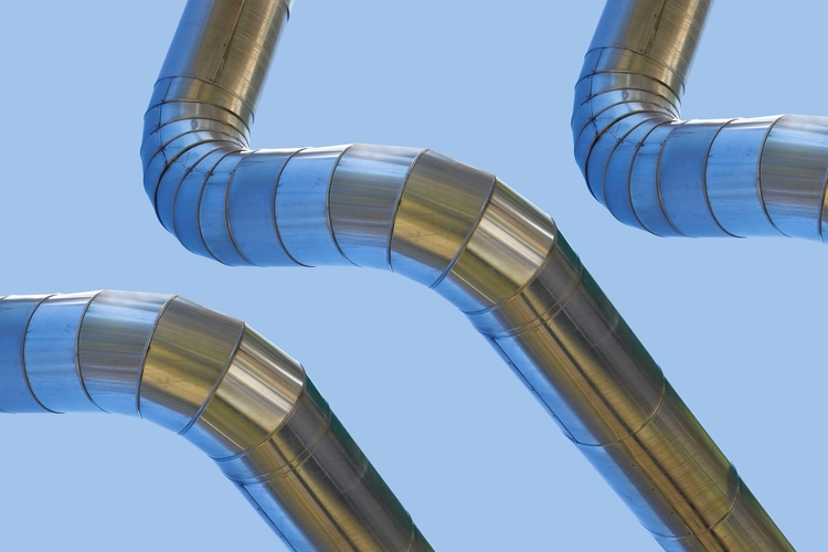 Geothermal stainless steel power pipe structure of a geothermal power station against a sky background