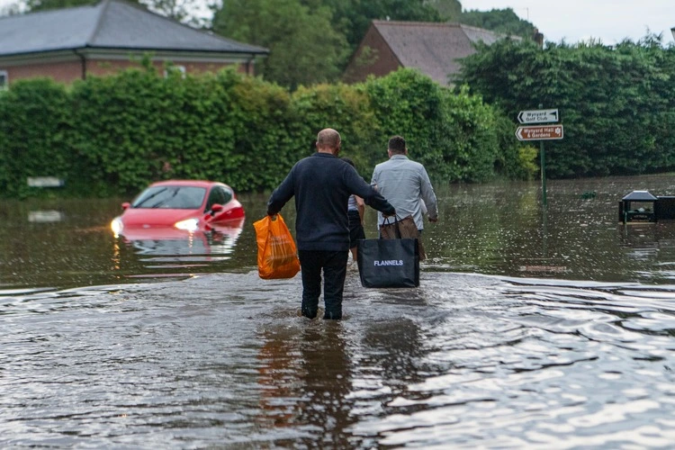 People are seen wadding back to their home in Wynyard, County Durham after flash floods.