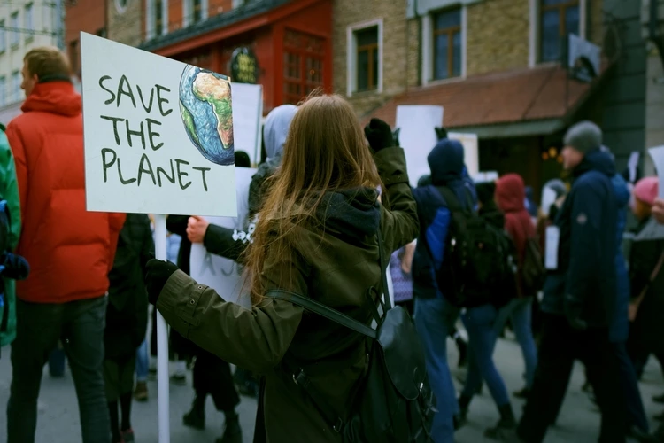 Activist person hold anti global warming banner. Eco demonstration placard. No climate change concept. City street picket background. World care rally Earth poster