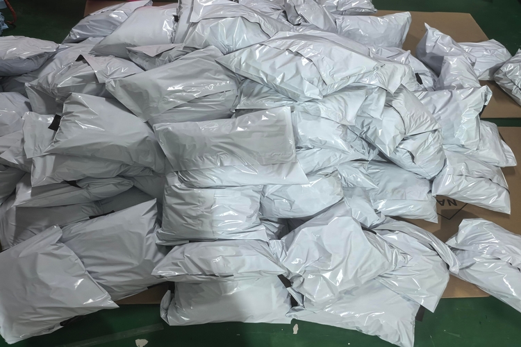 Guangzhou, China - view of white plastic shipping bags, indicating a high volume of e-commerce packages ready for processing.