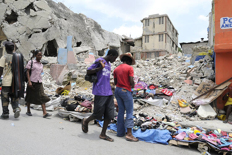 People buying and selling stuffs in front of a collapsed building in Port-Au-Prince, Haiti on August 21 2010.