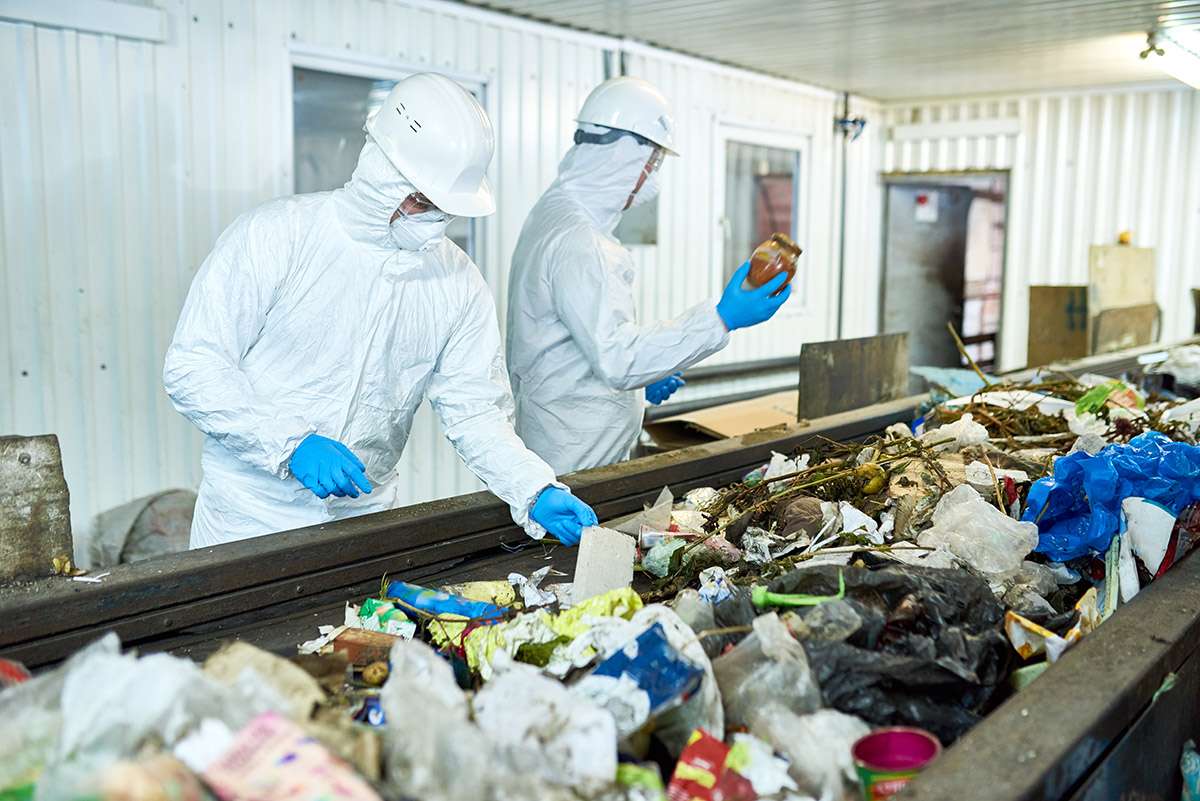 Workers at a waste processing plant sorting rubbish