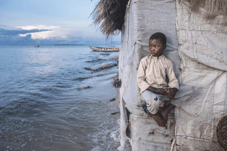 Nidole Karama, 8, perched on the side of one of the remaining huts on Nyangai Island in Sierra Leone