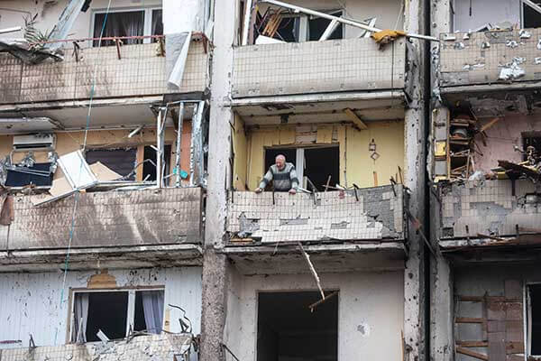 Man on bombed balcony in Kyiv