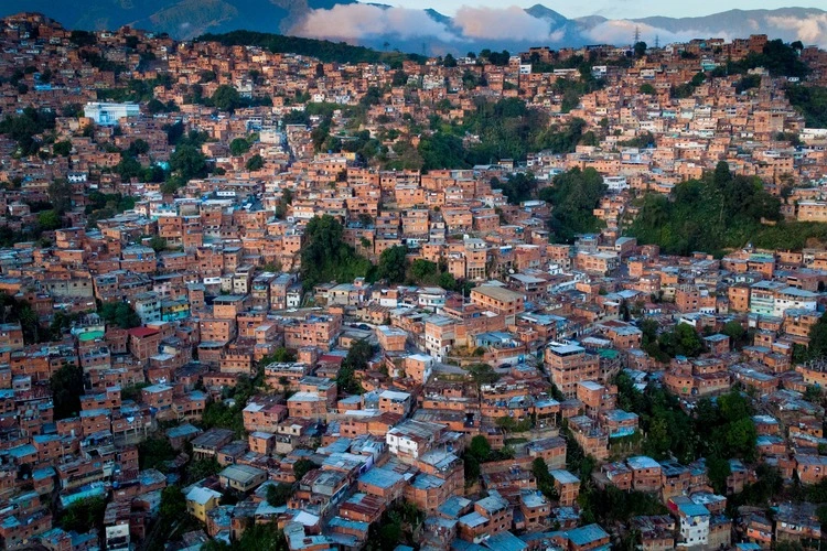 Aerial view of Caracas at sunset with the Petare neighborhood, the largest slum in Venezuela and latin america, with the Avila Mountain in the background.